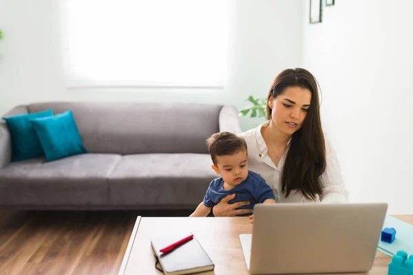 Beautiful Woman Working Home Laptop While Holding Her Baby — Stockfoto