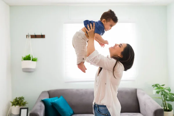Feliz Joven Mujer Sosteniendo Bebé Mientras Está Pie Sala Estar —  Fotos de Stock