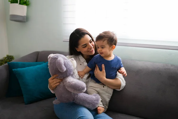 Matka Pokazuje Pluszowego Misia Synowi Siedząc Kanapie Domu — Zdjęcie stockowe