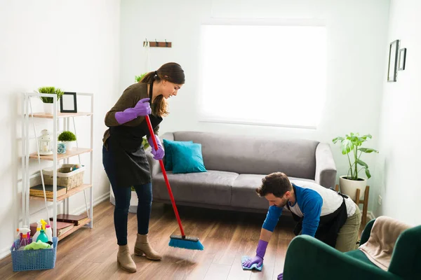 一对年轻夫妇在做所有家务活时一起扫地和擦拭地板的全景 — 图库照片
