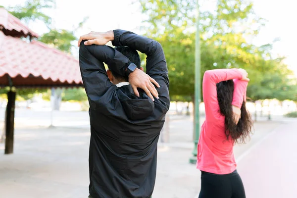 适合20多岁的男女在公园里做伸展运动 在锻炼前 一对夫妇热身的后视镜 — 图库照片
