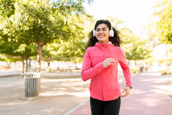 Ευτυχισμένη Νεαρή Γυναίκα Ακούει Μουσική Ακουστικά Και Πηγαίνει Για Τρέξιμο — Φωτογραφία Αρχείου