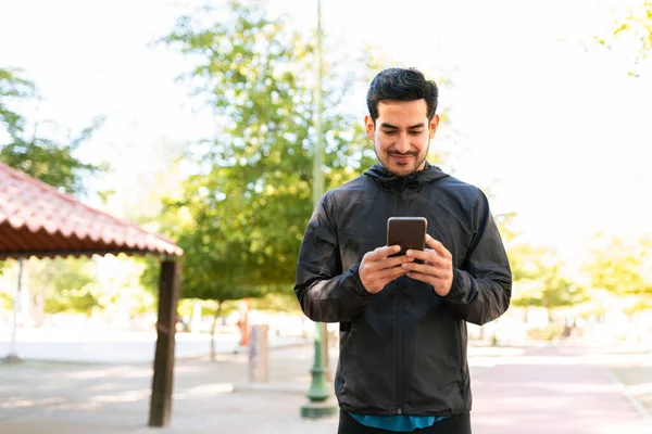 Yaşlarda Sportif Kıyafetler Giyen Yakışıklı Bir Spanyol Parkta Akıllı Telefonuyla — Stok fotoğraf