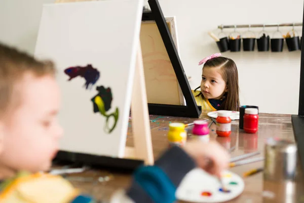 Piękne Elementarne Dzieci Fartuchach Malują Płótnie Podczas Zajęć Dla Dzieci — Zdjęcie stockowe