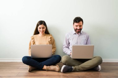 Dizüstü bilgisayarları olan çekici bir Latin çift yerde oturuyor ve internetten sevgili bulma sitesine ortak arıyorlar. 