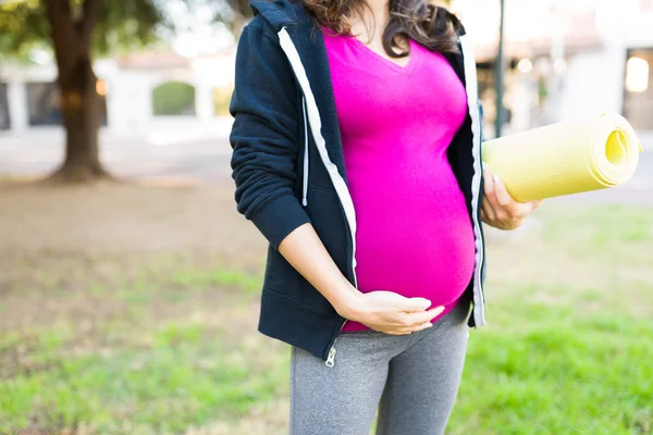 Έγκυος Γυναίκα Στα Της Αθλητικά Ρούχα Κουβαλώντας Ένα Στρώμα Γιόγκα — Φωτογραφία Αρχείου