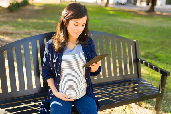 デジタルタブレットで本を読んでいる白人妊婦 子育てに関する本を楽しむ魅力的な女性 — ストック写真