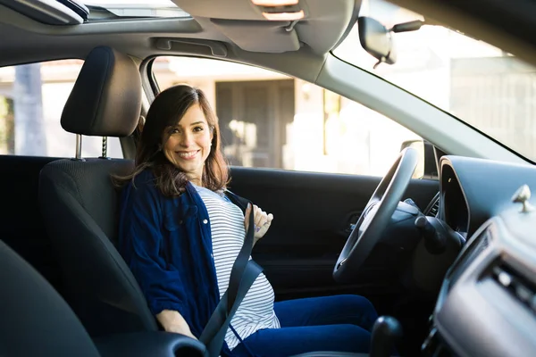 幸せな妊婦笑顔と置く彼女の安全シートベルト前に開始と彼女の車を運転 — ストック写真