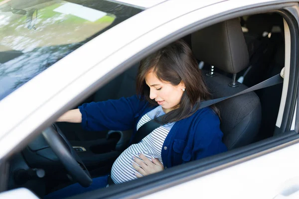 収縮と彼女の胃の痛みを持つ美しい妊婦 心配している女性運転彼女のシートベルトで彼女の車 — ストック写真