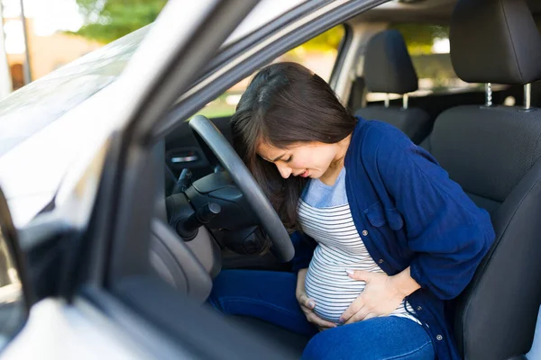 収縮を持っている間 白人の妊婦は彼女の車から出る 妊娠中の女性は病院に行き — ストック写真