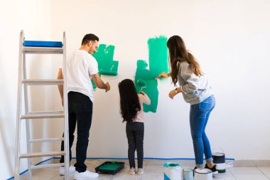 Gururlu anne ve baba kızlarına duvarları boyamada iyi iş çıkardığını söylüyor. Aile yeni evlerini yeniliyorlar.