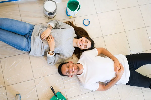 一个快乐的男朋友和女朋友躺在新家的地板上的头像 装修和重新装修房子后 这对迷人的夫妇休息一下 — 图库照片