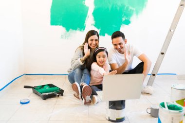 Genç İspanyol ailesi laptoptaki video görüşmesi sırasında arkadaşlarına ve akrabalarına merhaba diyor. Heyecanlı genç kadın, erkek ve kız evlerini yeniliyorlar.