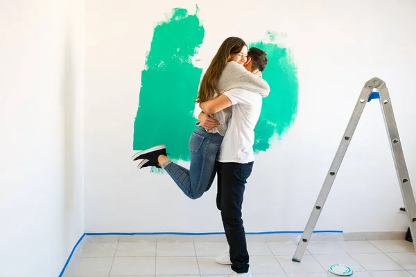 彼らの新しいアパートや家に移動することに興奮愛のカップル 彼らのリビングルームの壁を一緒に描くボーイフレンドとガールフレンド — ストック写真