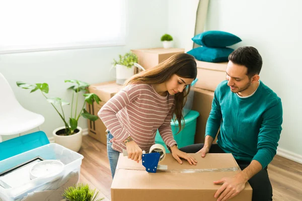 Latin couple packing their furniture before moving out of their apartment. Wife and husband sitting with all their things packed