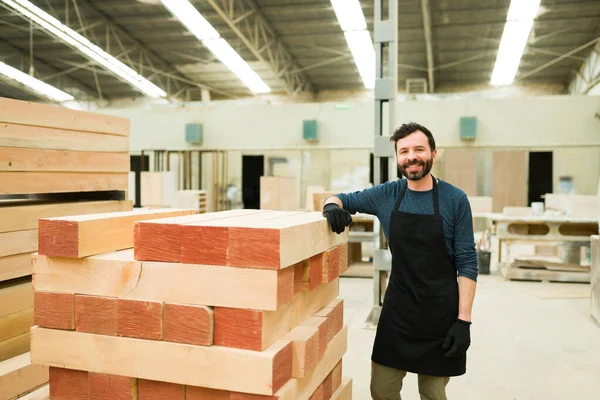 在一堆木板旁边摆姿势 微笑着的拉丁男人 在仓库和木材店工作的男工 — 图库照片