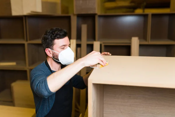 西班牙木匠在一家木材店的家具上撒沙 男木匠 戴着面罩 在书架上做最后一次触摸 — 图库照片
