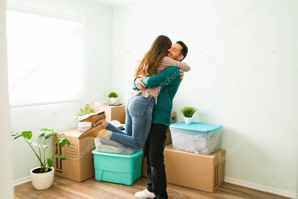 Young wife and husband excited to move into a new home. Couple in love hugging and smiling during their moving day