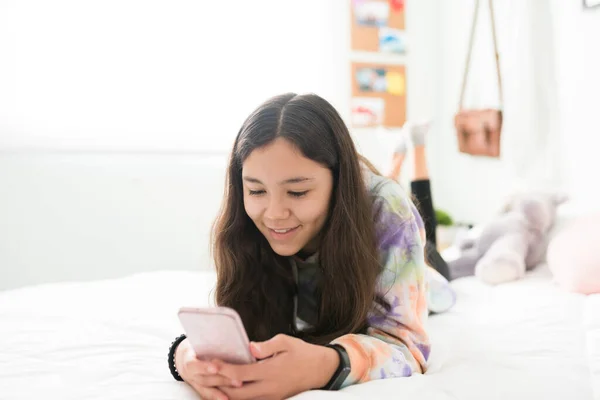 Lächelndes Teenie Mädchen Auf Dem Bauch Bett Liegend Und Sms — Stockfoto