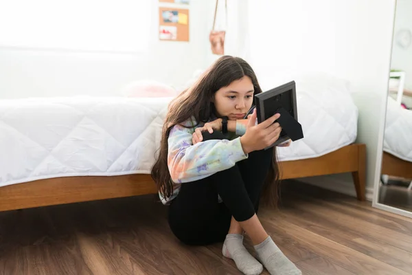 Melancholisches Teenager Mädchen Das Traurig Auf Ein Familienfoto Ihrem Schlafzimmer — Stockfoto