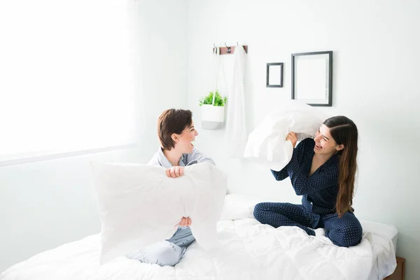 Mooie Jonge Vrouwen Met Een Pyjama Lachend Een Kussengevecht Bed — Stockfoto