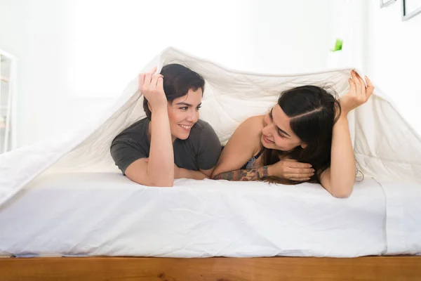 两个恋爱中的快乐女人躲在被窝里快乐浪漫的同性恋夫妇在卧室休息和放松 — 图库照片