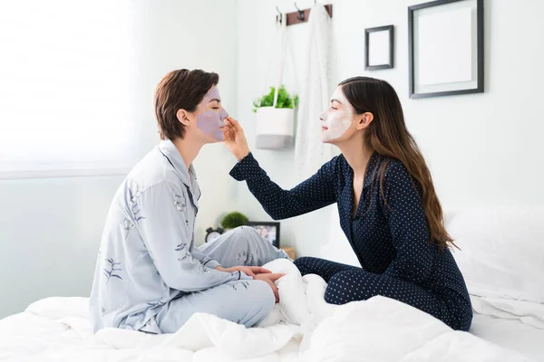 Beautiful Young Woman Applying Exfoliating Face Mask Her Pretty Friend — Stock Photo, Image
