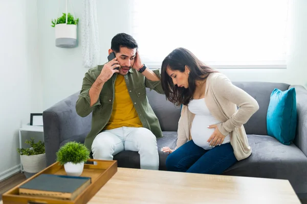 在家里紧张而害怕的拉丁男人用智能手机拨打911紧急呼救电话 为他怀孕的妻子求援 — 图库照片