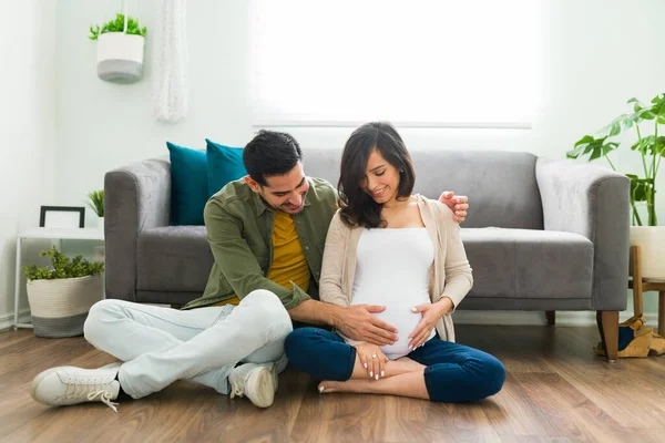 Adorable Couple Sitting Living Room Floor Caressing Belly Pregnant Woman — Stock Photo, Image