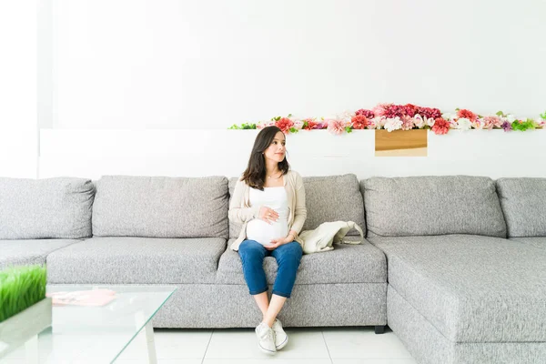 Pretty pregnant woman sitting in the waiting room of the doctor\'s office for a routine checkup and an ultrasound of her baby