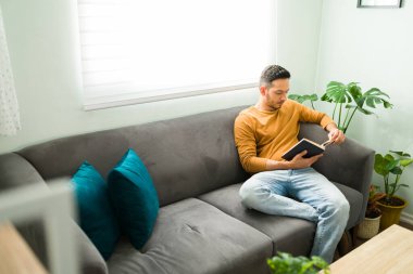 Evde boş bir gün geçirirken mutlu bir adamın portresi. İyi bir ruh sağlığı çalışanını, erkeği, erkeği, bir kişiyi korumak için suluboya resim yapan pozitif Latin bir adam., 