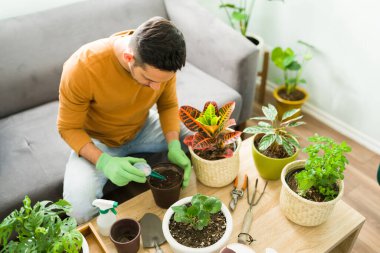 Evde boş bir gün geçirirken mutlu bir adamın portresi. İyi bir ruh sağlığı çalışanını, erkeği, erkeği, bir kişiyi korumak için suluboya resim yapan pozitif Latin bir adam., 