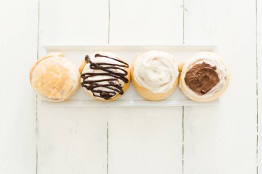 Çikolata soslu, elma soslu ve fındıklı kremalı tarçınlı börekler. Tatlı tatlı hazır ahşap mutfak masasında yemek için