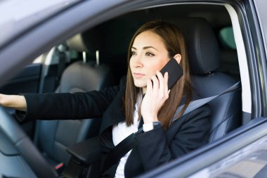 Harika bir iş kadını, araba kullanırken iş müşterisiyle telefonda konuşuyor. Güzel bir iş kadını iş yerinden bir iş arkadaşını arıyor.