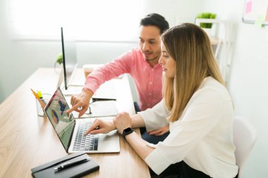 Güzel bir iş adamının laptopuna bakması ve erkek iş arkadaşını dinlerken sunumu. 