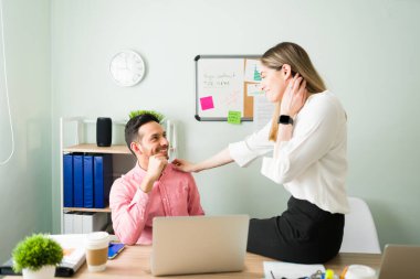 Beyaz bir kadın ofiste masalarında otururken yakışıklı bir adamla flört ediyor. Profesyonel bir iş adamı erkek arkadaşının omzuna dokunuyor. 
