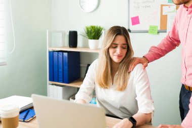 Beyaz kadın, erkek patronu ofiste uygunsuz bir şekilde omzuna dokunduğu için kendini rahatsız hissediyor. Cinsel taciz kavramı