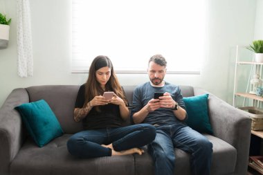 Evli çift evde boş bir gün geçiriyor. Genç kadın ve erkek, sosyal medya ve akıllı telefonlarıyla mesajlaşırken kanepede dinleniyorlar.