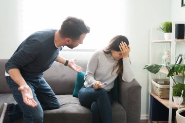 Kızgın Latin adam, hamilelik testinin pozitif sonuçlarını öğrendikten sonra bağırıp kız arkadaşıyla kavga ediyor.