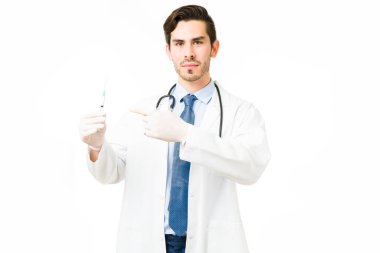 Ciddi profesyonel doktor aşı ya da şırıngayla ilaç tutarken göz teması kuruyor. Eldivenlerle bir hastayı aşılamaya hazırlanan tıp uzmanı.