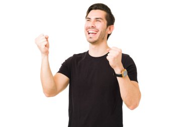 Çekici genç adam zafer kutlaması yapıyor ve başarısı ve iyi haberleri sayesinde çığlık atıyor. 20 'li yaşlarındaki heyecanlı adam gülüyor ve eğleniyor.