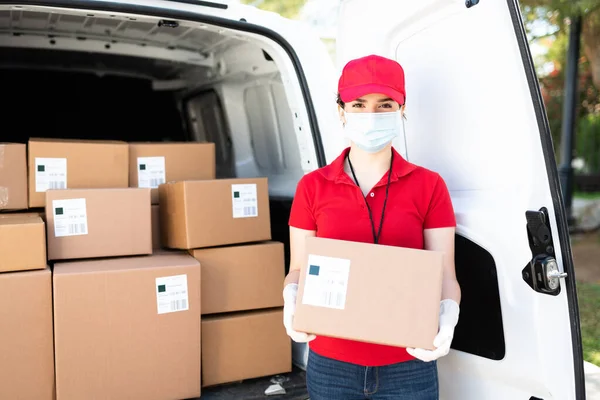 フェイスマスクと手袋を着用した白人労働者の肖像で コロナウイルスパンデミックの間に配達サービスと荷物を運ぶ — ストック写真