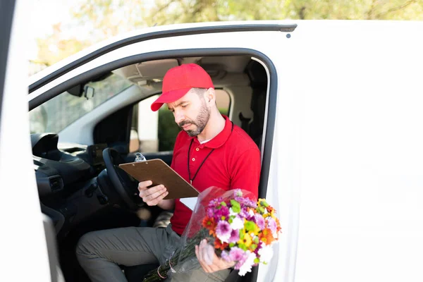 Atrakcyjny Latynoski Pracownik Czyta Dane Kontaktowe Klienta Podczas Wysiadania Ciężarówki — Zdjęcie stockowe