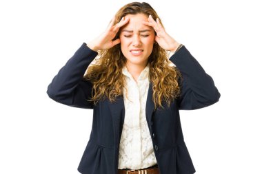 Latin iş kadını bunalmış ve çok çalışmış hissediyor. Stresli mesleki işi yüzünden baş ağrısı ya da migreni olan endişeli genç bir kadın. 