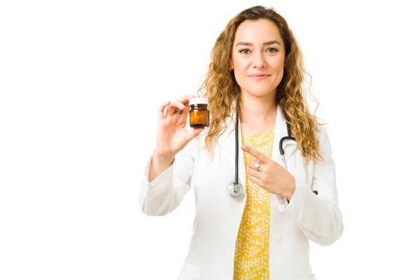Piękna Kobieta Lekarz Gospodarstwa Wskazując Butelkę Tabletek Lub Witamin Pozytywny — Zdjęcie stockowe