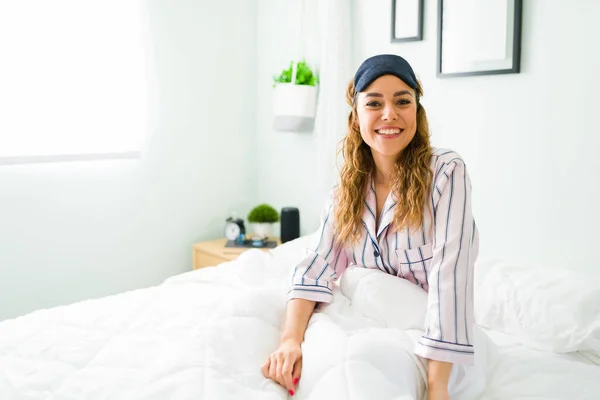 Jovem Alegre Sorrindo Enquanto Senta Sua Cama Branca Depois Acordar — Fotografia de Stock