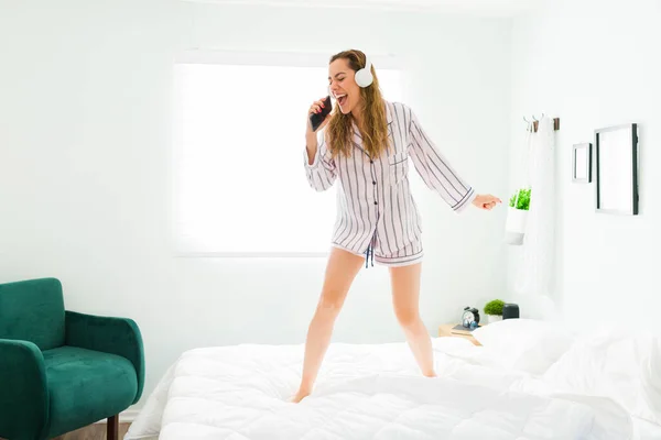 Kulaklıklı Latin Kadın Yatakta Dans Ederken Karaoke Yapıyor Şarkı Söylüyor — Stok fotoğraf