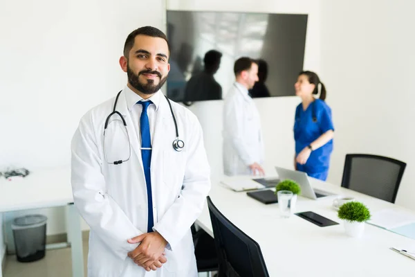 Happy to help his patients. Successful hispanic doctor and hospital director in a white coat getting ready to start a meeting with the medical board