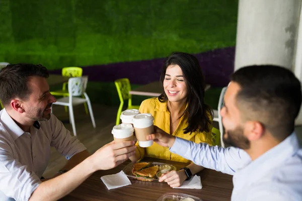 オフィスを出た後はフードコートで一緒にランチを食べながら 陽気な同僚たちがコーヒーを片手に乾杯 — ストック写真