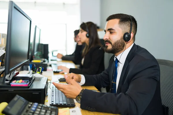 Müşteri hizmetleri yöneticisi bir müşteriden telefon alıyor ve teknik destek öneriyor. Çağrı merkezinde çalışan yakışıklı satış temsilcisi